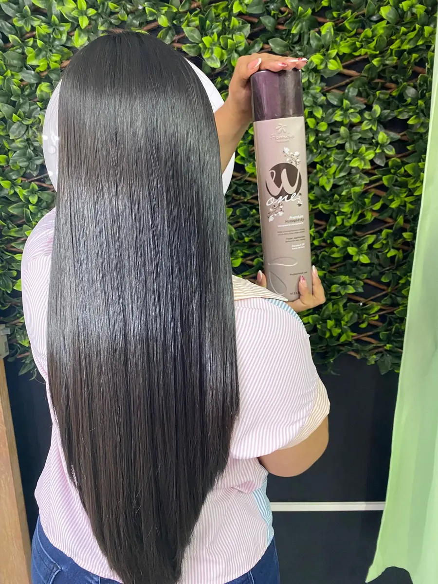 Clienta con cabello negro liso hasta la cintura sosteniendo el producto W One
